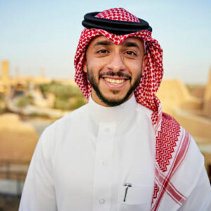 1 (2) Head and shoulders view of bearded Middle Eastern man in early 30s wearing traditional dish dash, kaffiyeh, and agal and smiling at camera. Property release attached.